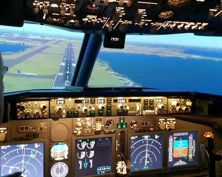 the cockpit of a boeing7371 flight simulator and the view of the runway