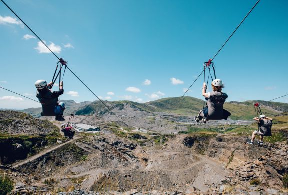 people going down zip lines over a quarry on a zip world titan experience day