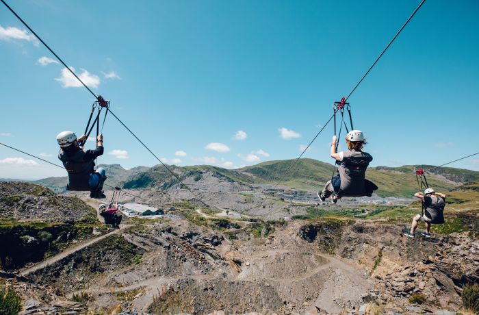 people going down zip lines over a quarry on a zip world titan experience day