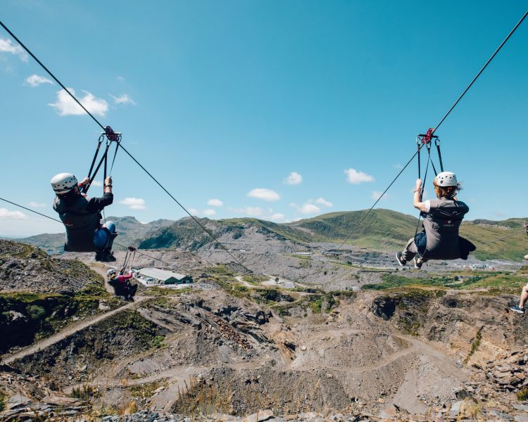 people going down zip lines over a quarry on a zip world titan experience day