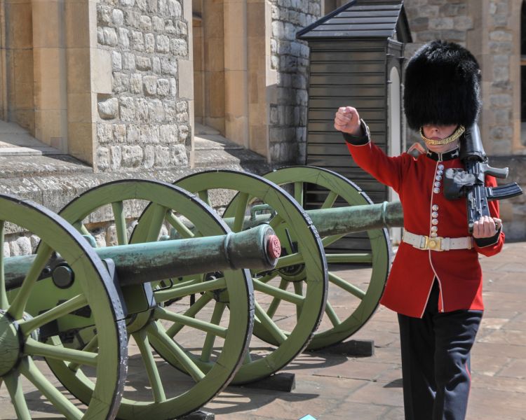 a guard marching outside buckingham palace in traditional uniform