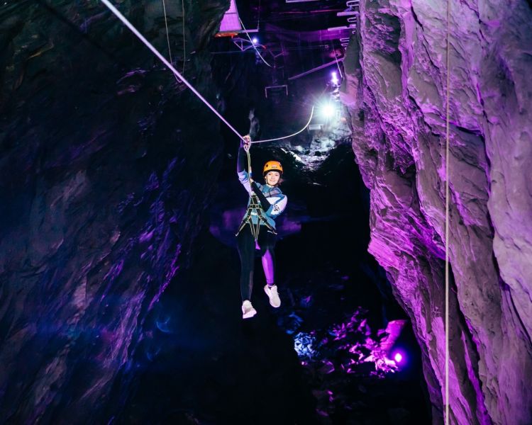 person making their way through an underground cavern experience day at zip world