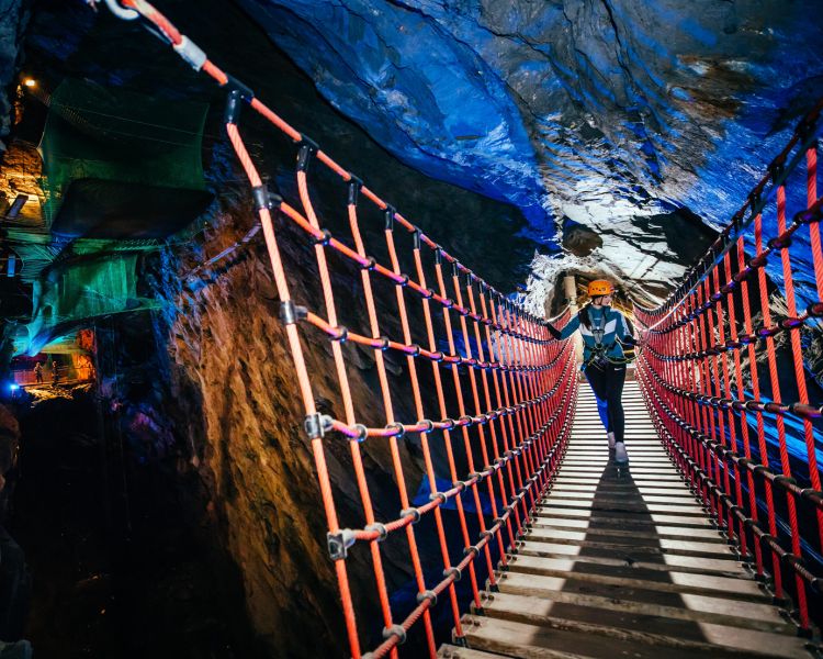 person making their way through an underground cavern experience day at zip world