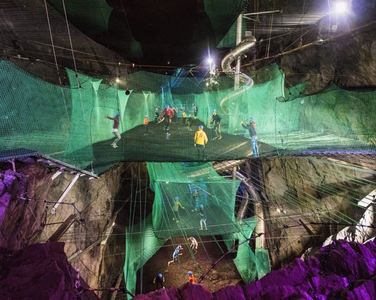 people bouncing on a trampoline inside a cave on a bounce below experience day