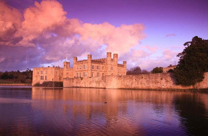 leeds castle seen across the river under a pink sky