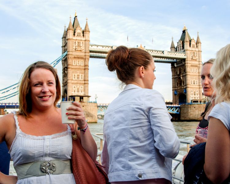 people in london with tower bridge behind them