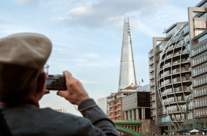 man taking photo of the shard on a sightseeing bus tour around london