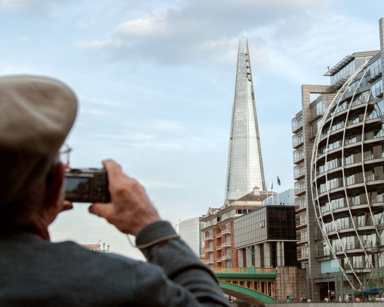 man taking photo of the shard on a sightseeing bus tour around london
