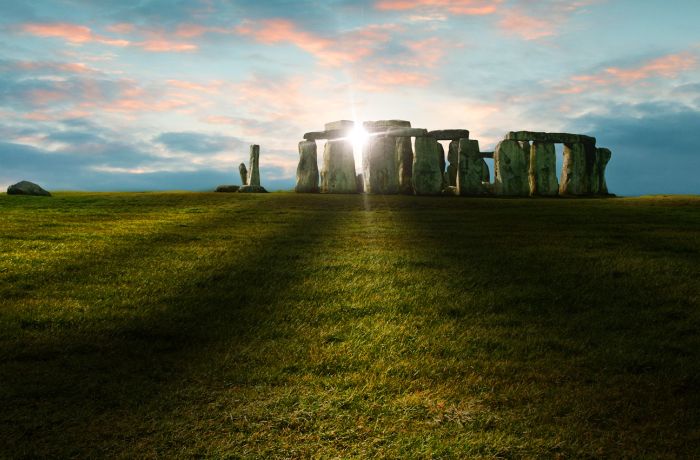 view of stonehenge with sunlight shining through the stones