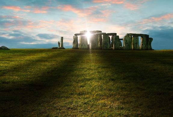 view of stonehenge with sunlight shining through the stones