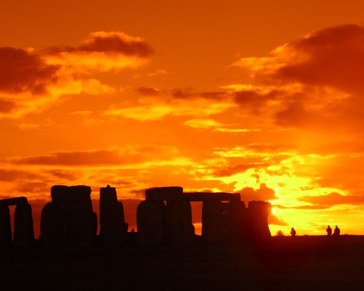 view of stonehenge with sun setting behind the stones