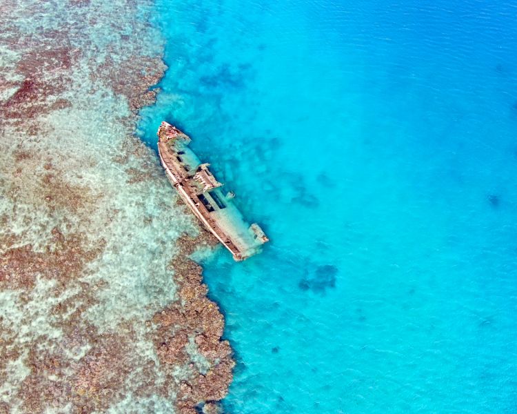shipwreck in tropical waters seen on a remote drone flying experience