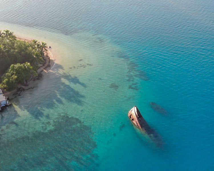 shipwreck in tropical waters seen on a remote drone flying experience
