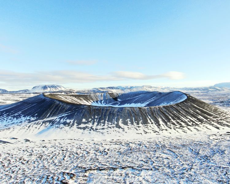 crater covered in snow seen on a remote drone flying experience