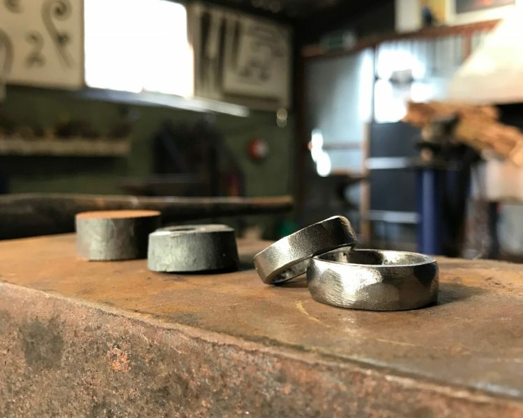 two silver wedding rings in a workshop as part of a ring making experience day