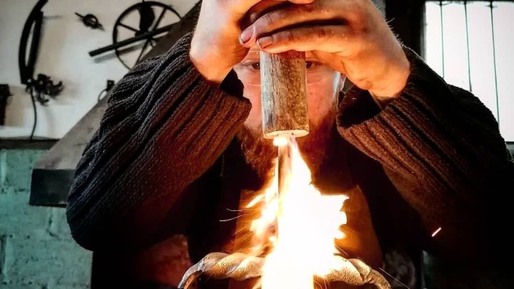 person at a forge on a sword making experience