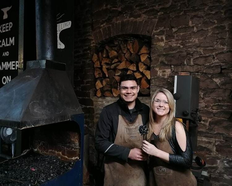 man and woman in a forge on a couples blacksmith experience