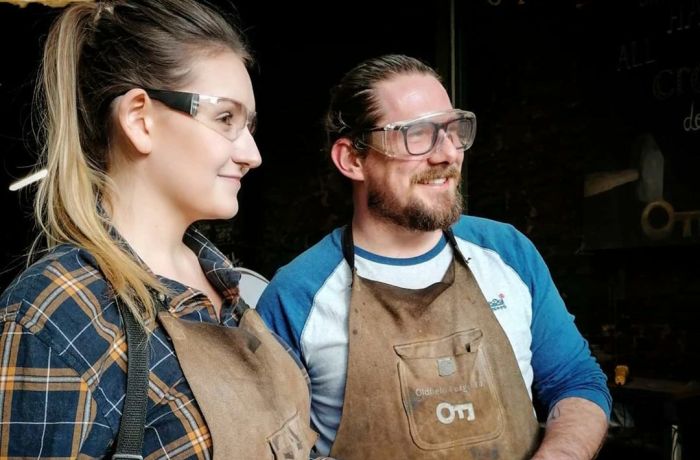 man and woman holding knives they have made on a just for fun blacksmith experience