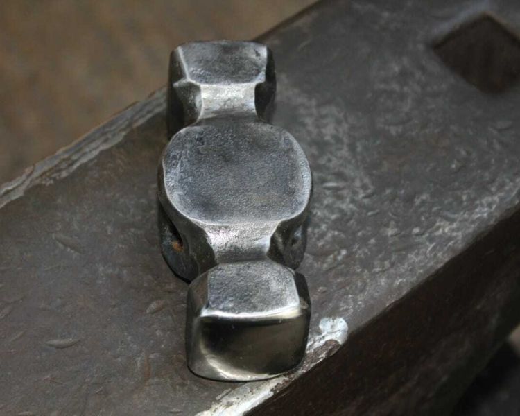 a hammer head made in a forge on a hammer making blacksmith experience
