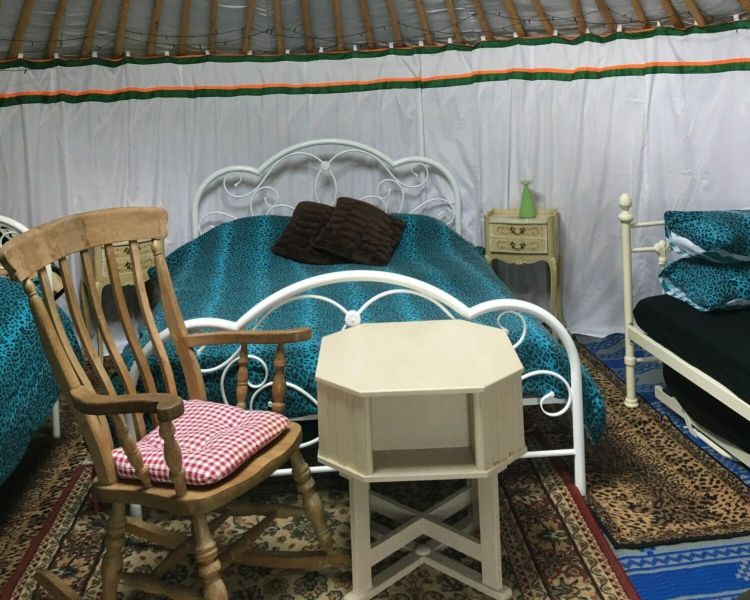 inside one of the devon yurts showing beds, tables and chairs