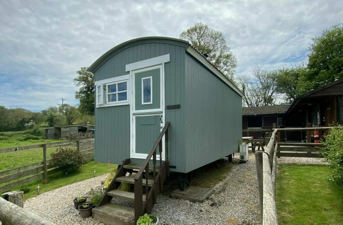 a shepherds hut set in the grounds of devon yurts