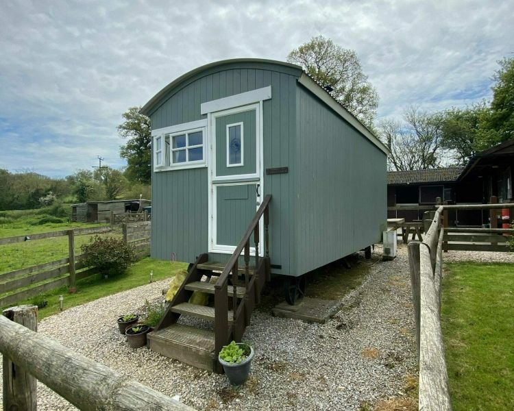a shepherds hut set in the grounds of devon yurts