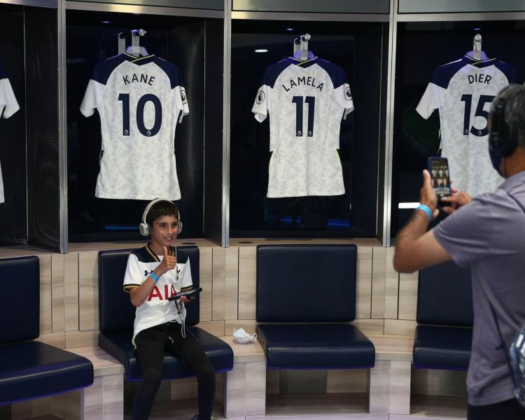 young boy having his photo taken in the players dressing room on a wembley stadium tour