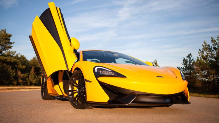 yellow supercar with drivers door lifted up at car chase heroes driving experience day