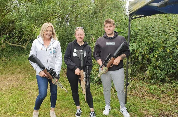 three people holding air rifles posing for photo on an air rifle shooting experience day