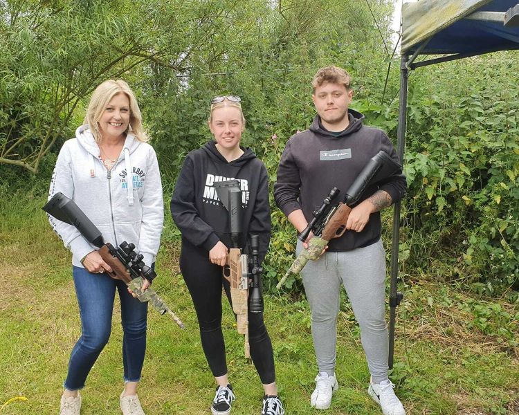 three people holding air rifles posing for photo on an air rifle shooting experience day