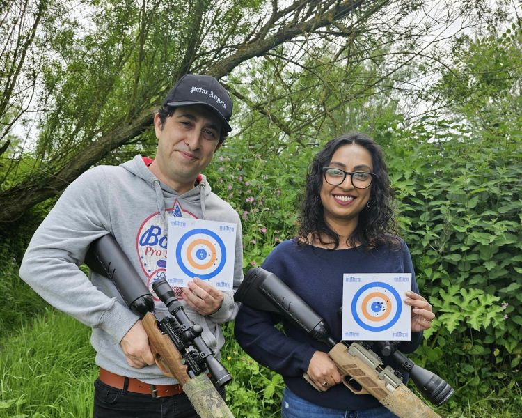 a man and a woman holding their target sheets on an air rifle shooting experience day
