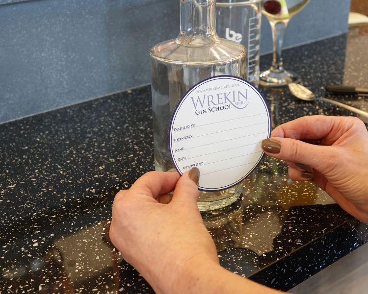 putting label on bottle on gin making experience in shropshire