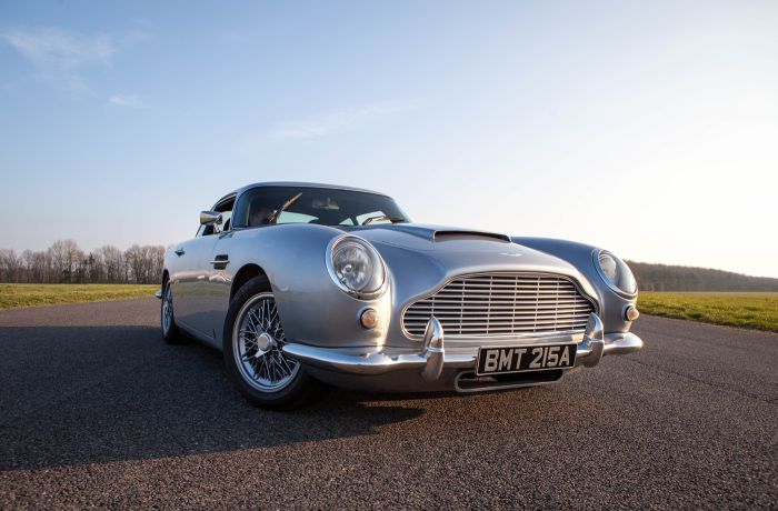 a silver db5 aston martin on the side of a race track as part of a driving experience day