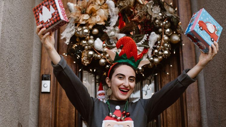 Woman dancing wearing christmas jumper and christmas tree headband