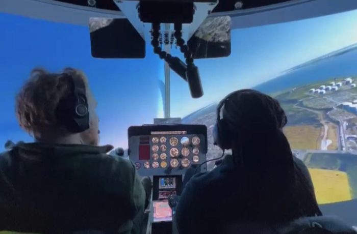 two people in a helicopter flight simulator as part of a flight simulator experience with lunch for two