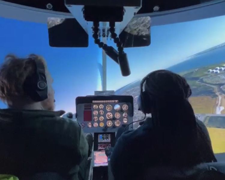 two people in a helicopter flight simulator as part of a flight simulator experience with lunch for two