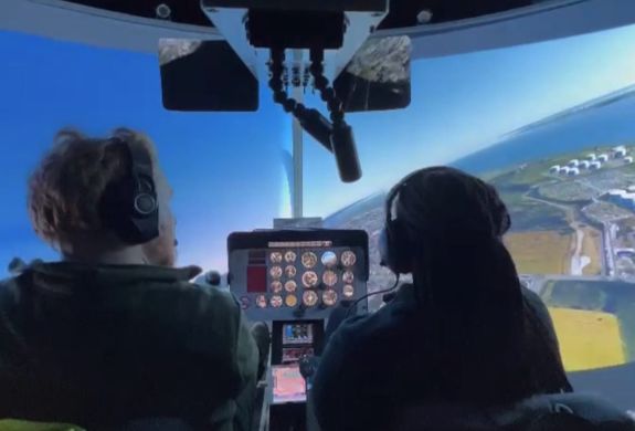 two people in a helicopter flight simulator as part of a flight simulator experience with lunch for two