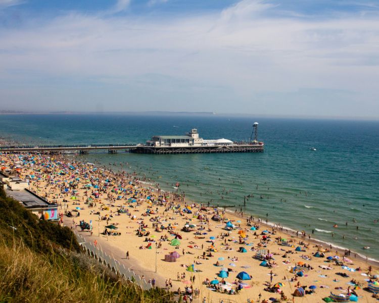 View of bournemouth beach and the pier on a summers day with lots of people on the beach...