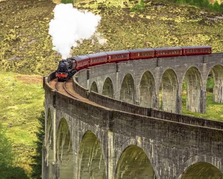 The jacobite steam train crossing the glenfinnan viaduct in the west coast of scotland...