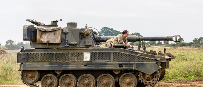 the abbott spg tank being driven across a muddy field on a tank driving experience day