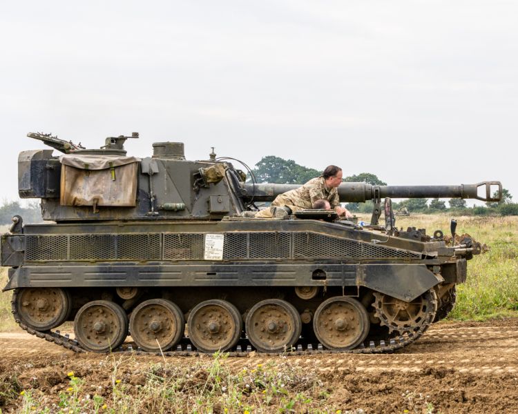 the abbott spg tank being driven across a muddy field on a tank driving experience day