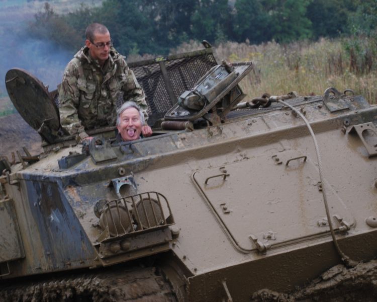 man pulling a silly face whilst driving a military tank on a tank driving experience day