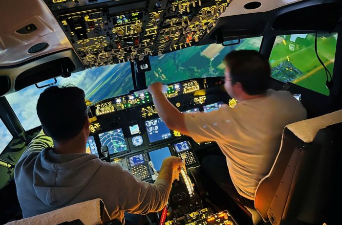 two people in the cockpit of a Boeing 737 - 800NG making flight checks on a simulator experience