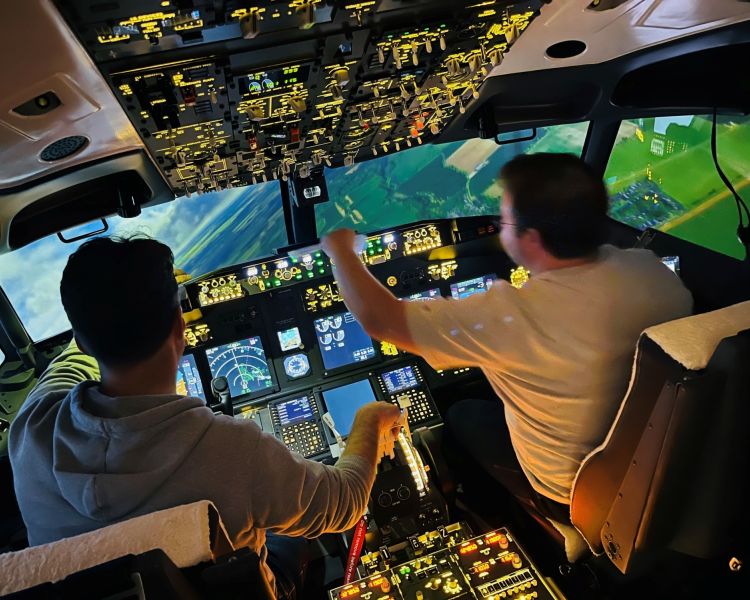 two people in the cockpit of a Boeing 737 - 800NG making flight checks on a simulator experience