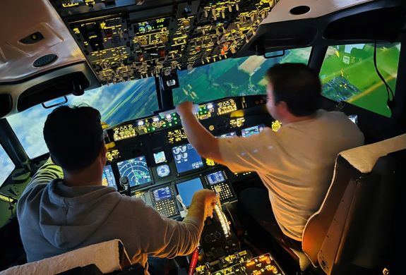 two people in the cockpit of a Boeing 737 - 800NG making flight checks on a simulator experience