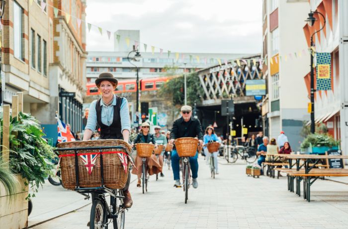 group of people riding vintage bicycles through london's streets on a bike sightseeing tour