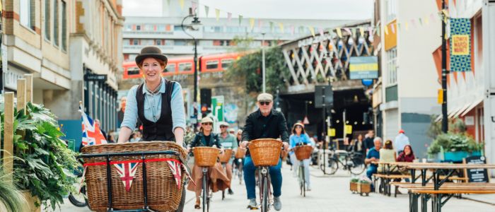 group of people riding vintage bicycles through london's streets on a bike sightseeing tour