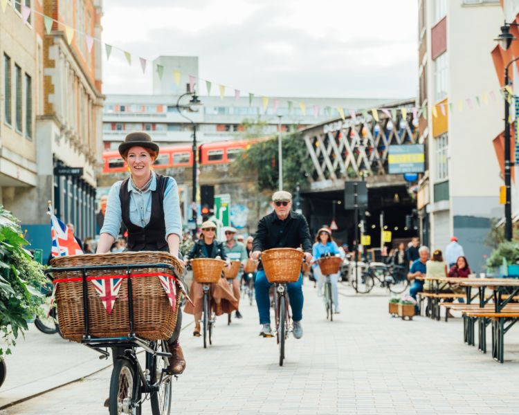 group of people riding vintage bicycles through london's streets on a bike sightseeing tour