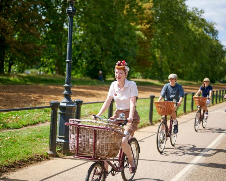 group of people riding vintage bicycles through london's hyde park on a bike sightseeing tour