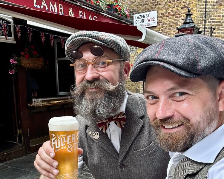 two men holding a pint of beer on a stop on a sightseeing bike tour in london